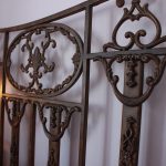 antique bed frame against lavender wall