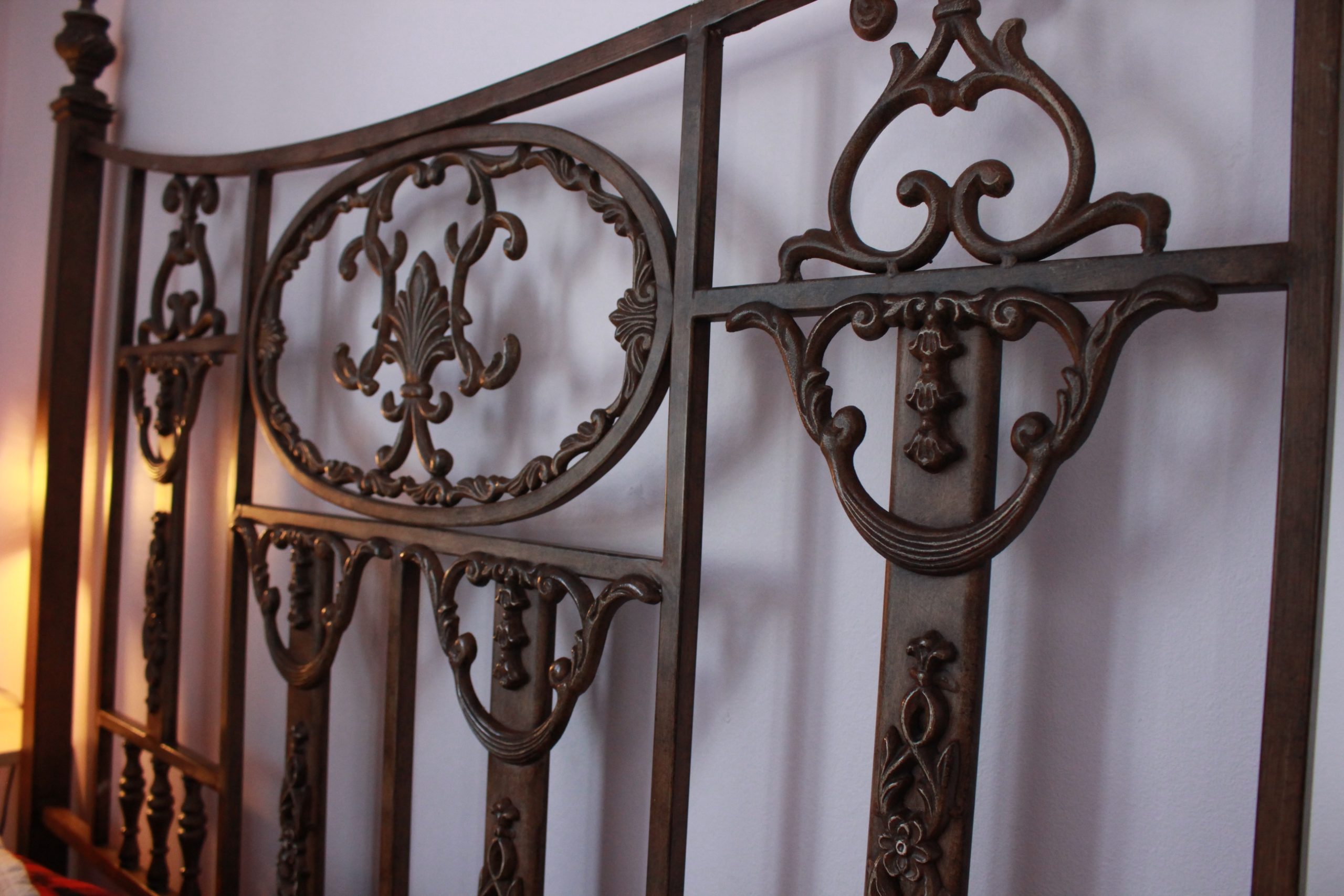 antique bed frame against lavender wall