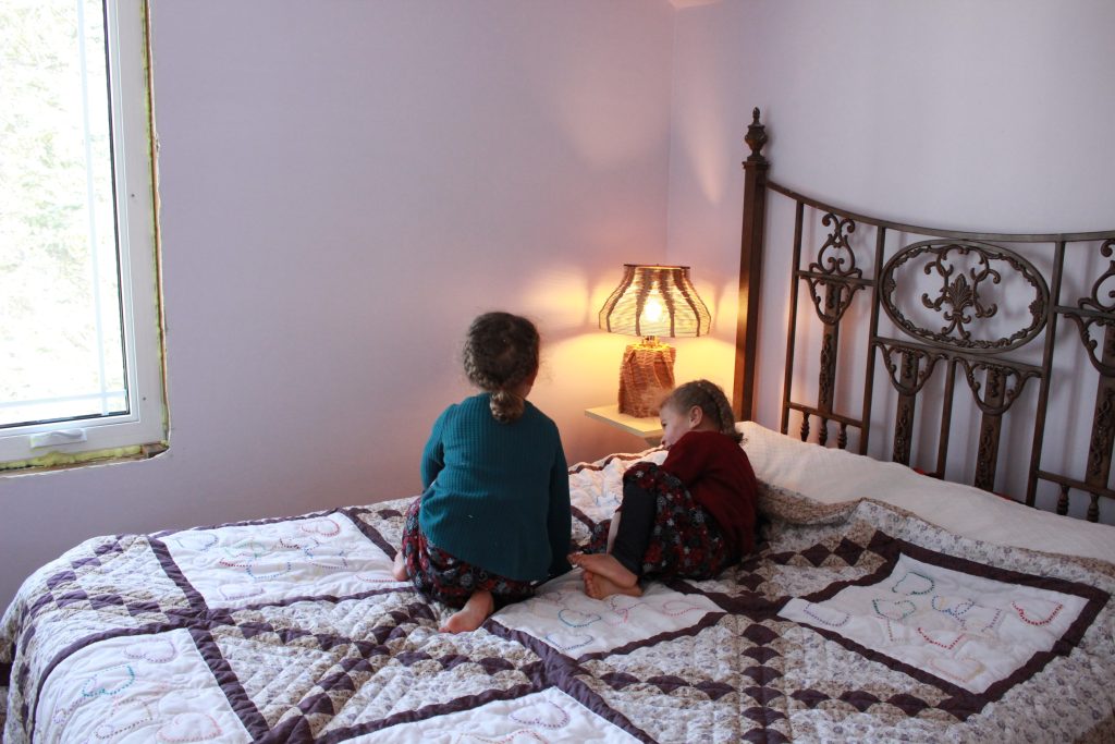 two girls sitting on a bed