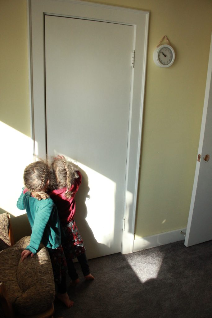 two girls peeking in a closet